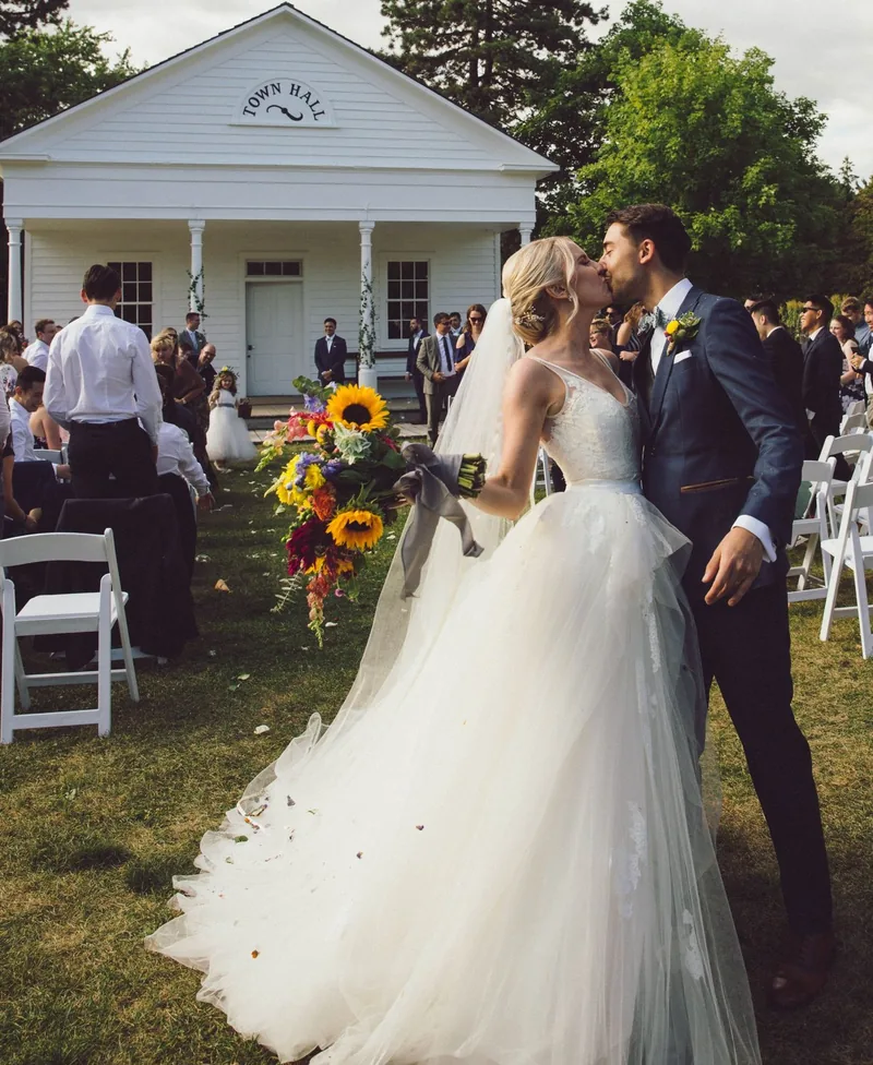 Newlyweds kissing during an outdoor ceremony