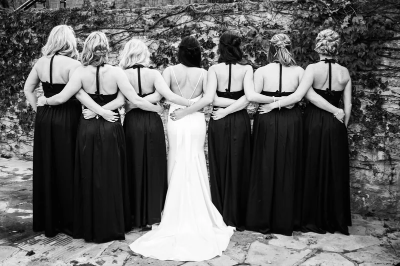 Bride and bridesmaids walking together in black and white