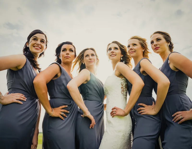 Bride and bridesmaids posing together outdoors
